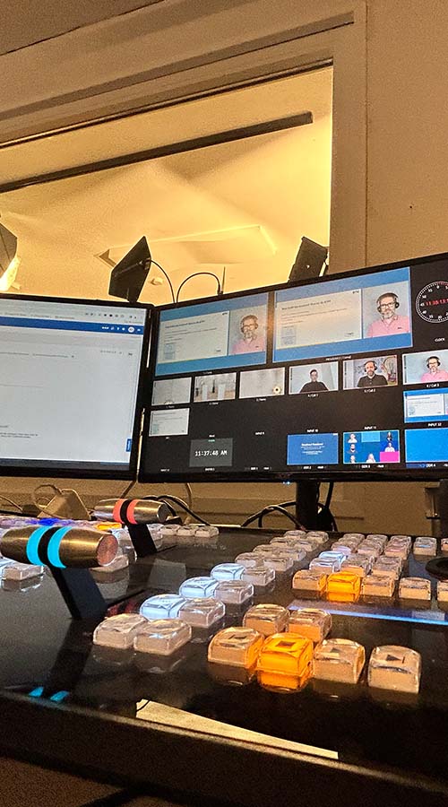 Professionelles Videomischpult mit zahlreichen Tasten, Reglern und Monitoren zur präzisen Steuerung und Umschaltung mehrerer Kameras während eines Live-Events.