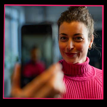 Frau nimmt sich selbst mit einem Smartphone auf im Rahmen einer Influencer-Kooperation