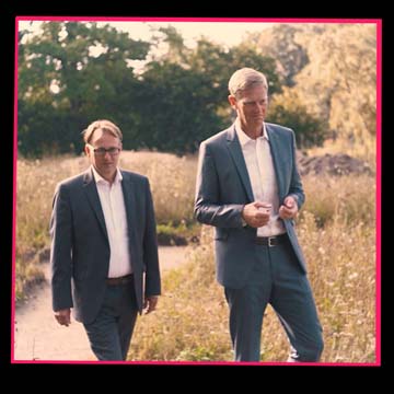 Kampagnenclip: Zwei Bank-Geschäftsführer stehen auf einer Blumenwiese und sprechen über ihr Projekt zum Erhalt der Natur.
