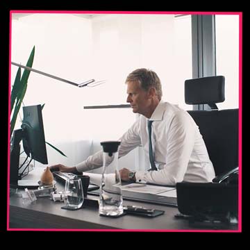 Livestreaming: Ein Bankmitarbeiter steht in einer professionellen Videoproduktionsumgebung.