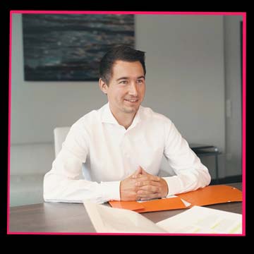 „Recruitingfilm: Ein Mann im Business-Look sitzt in einer Bewerbungssituation und blickt konzentriert nach vorn.“